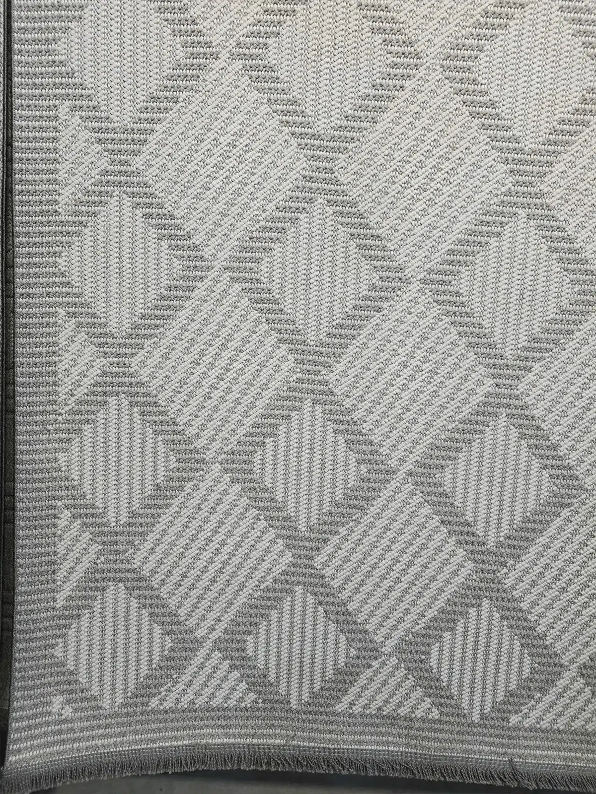 Bottom edge of Zephyr rug with visible fringe and diamond layout